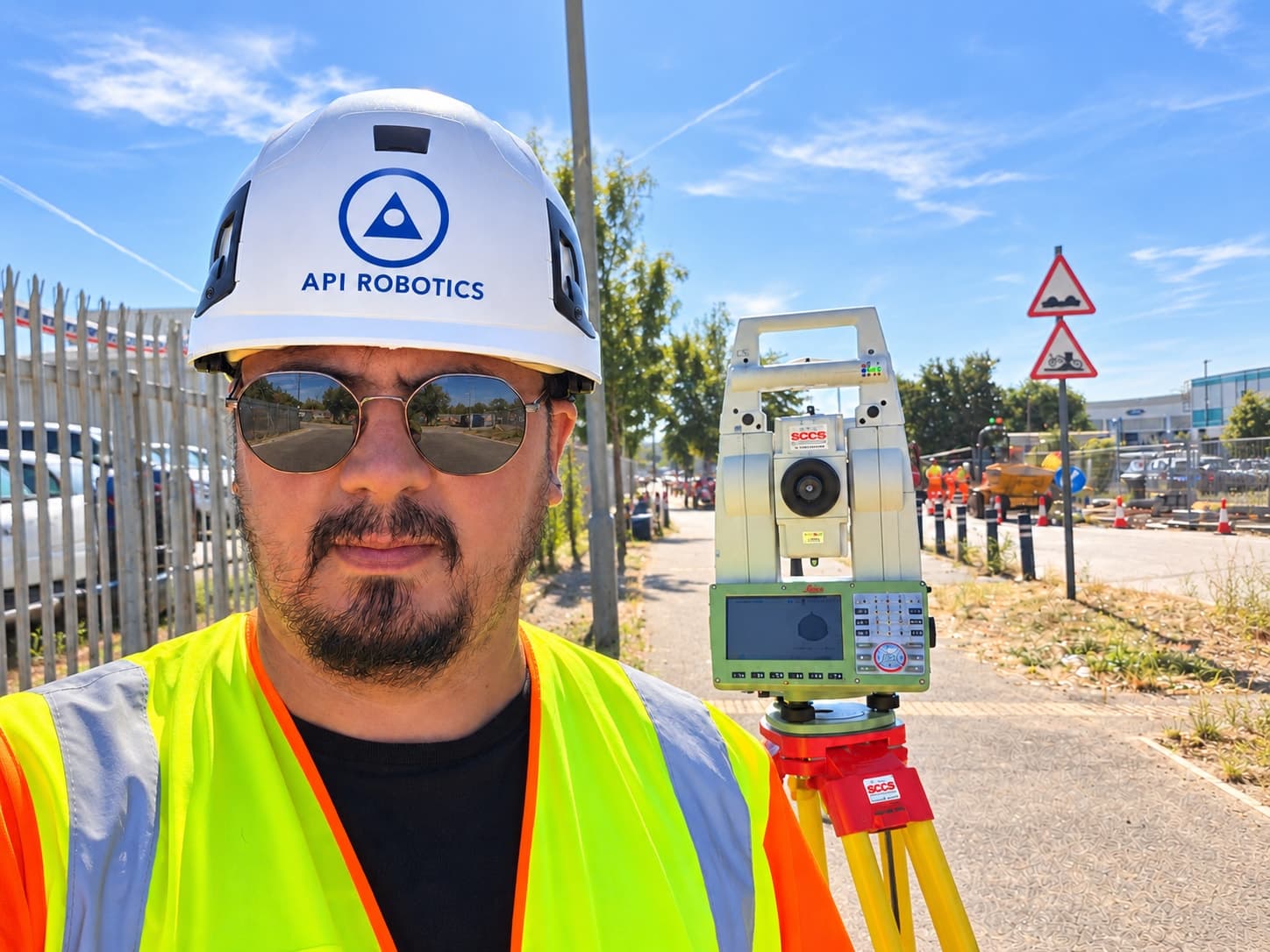 API Robotics engineer on site beside a robotic total station